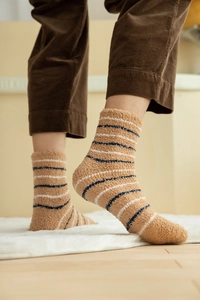 Close-up of thick coral fleece striped winter socks worn with corduroy trousers