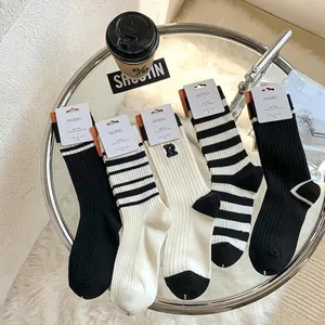 Detail view of cotton mid-calf socks with R letter embroidery and striped patterns