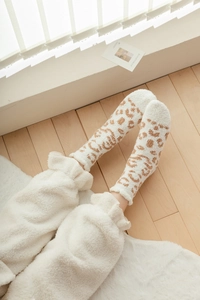 Detail of coral fleece winter socks with brown leopard print and cozy plush texture