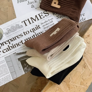 Détails de chaussettes en coton tricoté avec broderie lettre P et texture côtelée