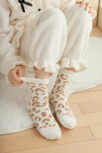 Detailed texture of thick leopard print coral fleece socks for winter warmth at home