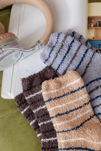 Close-up of thick coral fleece striped socks in grey, brown and beige colors