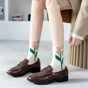 Retro white crew socks with pink floral pattern paired with vintage brown leather loafers