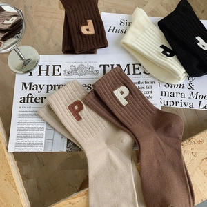 Détails de chaussettes en coton côtelé coloré avec broderie de lettres texturées