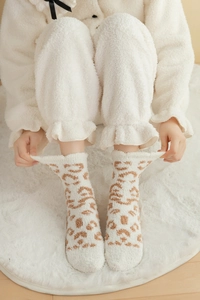 Close-up of thick coral fleece winter socks with brown leopard print pattern