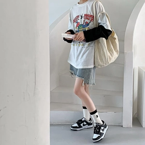 Street style outfit detail featuring white R-letter embroidered crew socks and sneakers