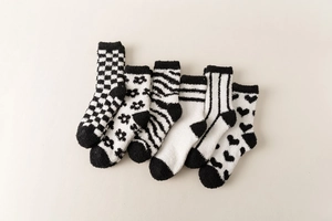 Detail of six pairs of warm black and white coral fleece socks with various patterns
