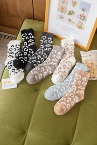 Close-up of fluffy coral fleece leopard print socks in various colors for winter warmth