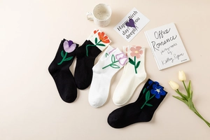 Detail of floral embroidered cotton socks in set of black white and beige colors