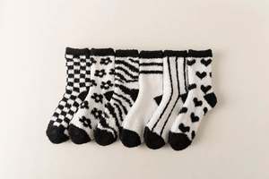 Flat lay of six pairs of black and white coral fleece socks with various patterns