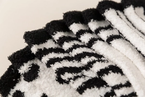 Detail of plush zebra stripe coral fleece socks showing soft and fluffy texture
