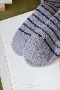 Close-up of thick grey and blue striped coral fleece socks showing soft plush texture