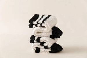 Close-up of thick black and white striped coral fleece socks with soft plush texture