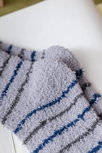 Macro shot of thick grey and navy striped coral fleece winter socks for home wear