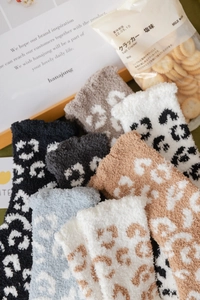 Detailed view of thick coral fleece socks with leopard patterns and soft winter textures