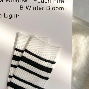 Close-up of black and white striped ribbed knit socks with premium embroidery details