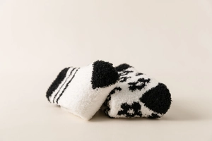 Close-up of soft black and white coral fleece socks with striped and animal patterns