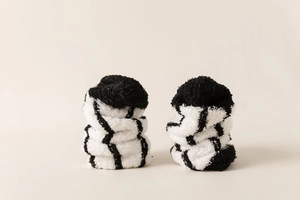 Close-up of thick black and white striped coral fleece socks with a plush fuzzy texture