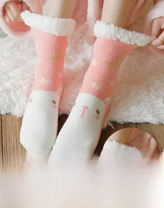 Close-up of thick coral fleece warm socks featuring cute animal faces and pink fabric