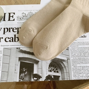 Gros plan de chaussettes en coton kaki clair avec poignets côtelés et maille fine
