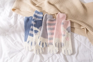 Flat lay of soft coral fleece cat paw socks in blue and pink for winter home comfort