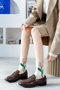 Close-up of casual cotton socks featuring cute pink tulip floral embroidery in ivory white