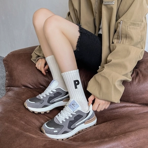 Gros plan sur des chaussettes avec broderie P associées à des baskets rétro