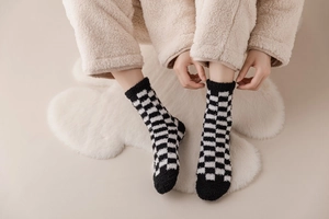 Close-up of black and white checkered fuzzy coral fleece socks for winter warmth