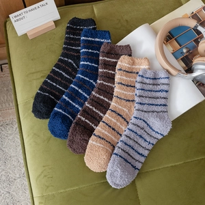 Five-pack of men's thick coral fleece crew socks with stripes in cozy home setting