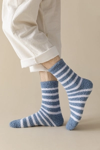 Close-up of soft blue and white striped coral fleece socks worn with corduroy pants