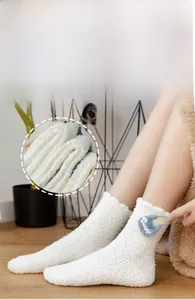 Detail of soft white coral fleece sock featuring a blue heart patch with Sweet text
