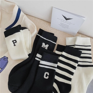 Retro varsity style crew socks with letter embroidery and stripes in black and white colors