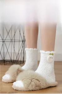 Close-up of fluffy coral fleece socks with cute carrot decor and plush slippers
