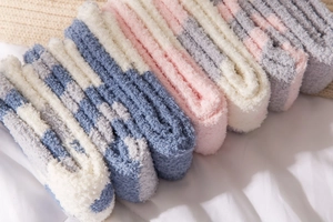 Detailed view of soft coral fleece textures on colorful winter cartoon cat paw socks