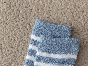 Close-up of thick blue and white striped coral fleece socks with a plush fluffy texture