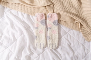 Detailed texture of fuzzy coral fleece socks with cute blue paw pattern for winter