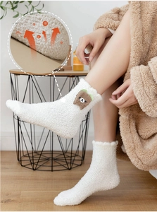 Detail of white coral fleece socks featuring a cute plush bear and breathable fabric texture