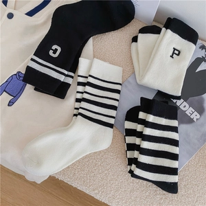 Close-up of winter thermal crew socks featuring letter embroidery and striped patterns