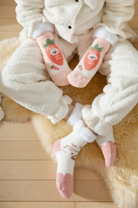 Detailed texture of coral fleece socks featuring cute rabbit and carrot embroidery