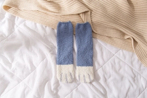 Detail of plush coral fleece cat paw socks showing thick thermal texture and blue contrast