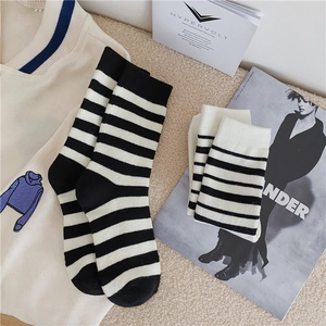 Detailed close-up of thick thermal striped cotton socks with embroidered letters and soft texture