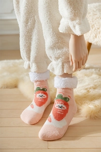 Detail of pink coral fleece socks featuring carrot patterns and white faux shearling cuffs