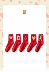 Detail of red mid-calf socks with cute bear motifs and Sucre embroidery for New Year