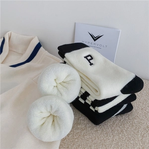 Detailed view of thick white fleece lining and embroidered letter P on crew socks