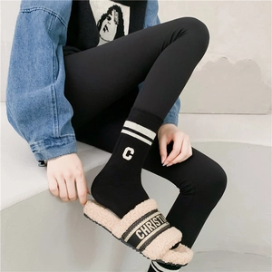 Close-up of black sports socks with white stripes and plush fleece slippers with embroidery