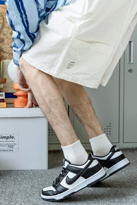 Detail shot of white cotton crew socks paired with minimalist black and white sneakers