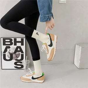 Detail of white striped terry socks with letter embroidery worn with retro sneakers