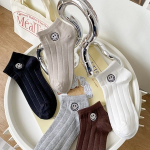 Détail de cinq paires de chaussettes basses en coton avec de mignons motifs smiley brodés