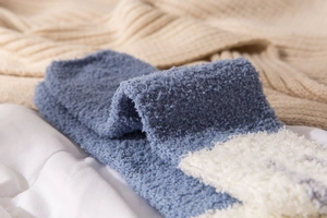 Macro shot of soft blue and white striped coral fleece socks with fluffy warm texture