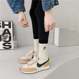 Thick winter terry socks with black stripes and embroidery worn with casual sneakers